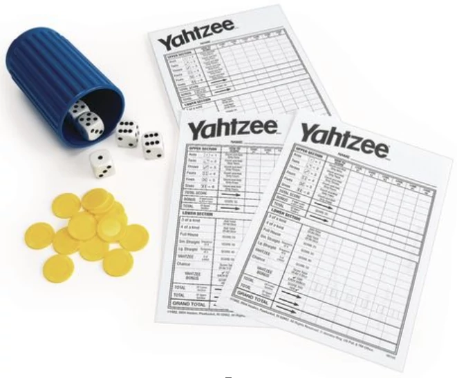 The contents of a Yahtzee set - dice, shaker, scorecards, and bonus chips.